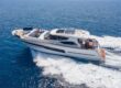 Luxury motor yacht cruising across calm blue sea