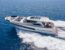 Luxury motor yacht cruising across calm blue sea