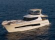White flybridge yacht on calm open water
