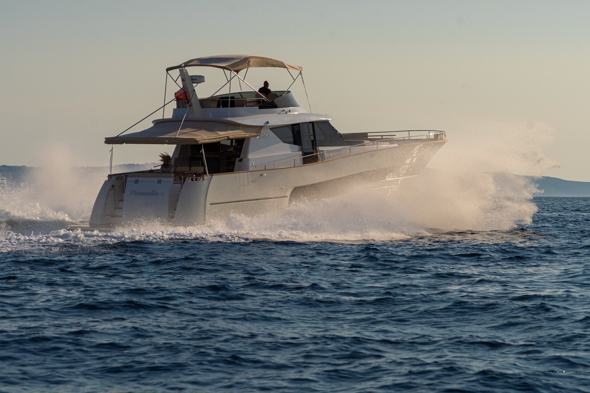 Monachus MY70F Underway Flybridge yacht cruising through sea spray